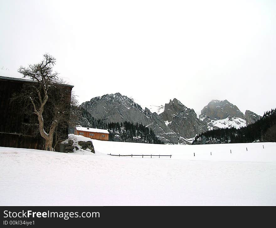 A barn in front of the Alps of eastern Switzerland. A barn in front of the Alps of eastern Switzerland.