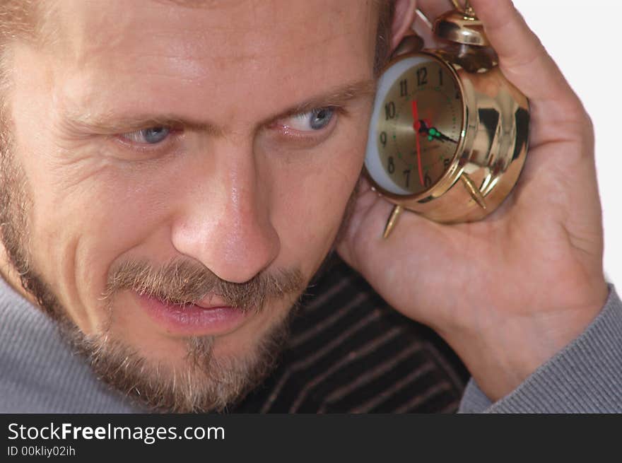 A businessman listening to an alarm clock sound. A businessman listening to an alarm clock sound