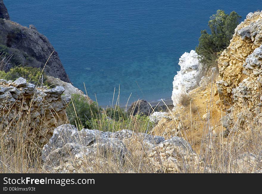 Blue sea between colour rocks. Blue sea between colour rocks