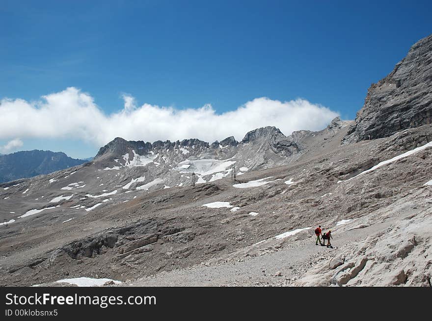 View of the alps with hikers in the distance. View of the alps with hikers in the distance