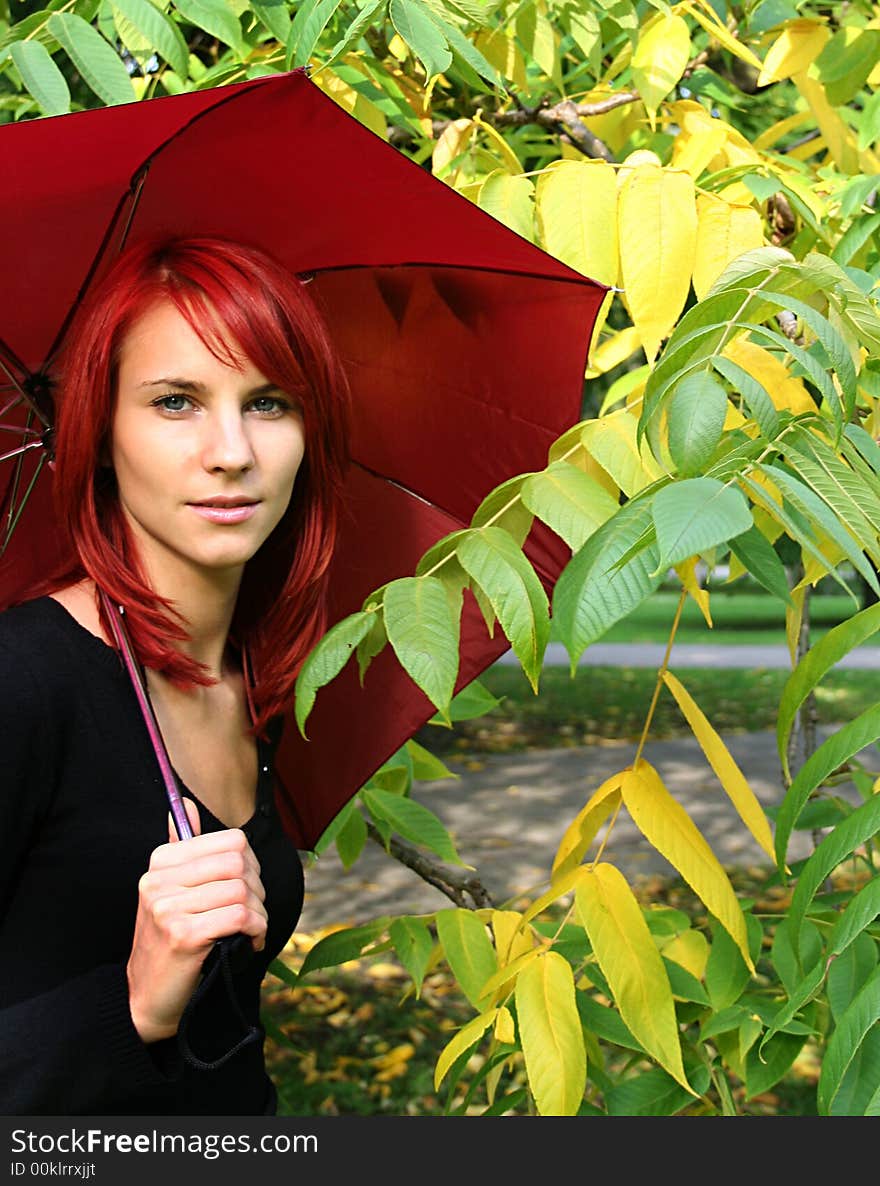 Beautiful girl under red umbrella