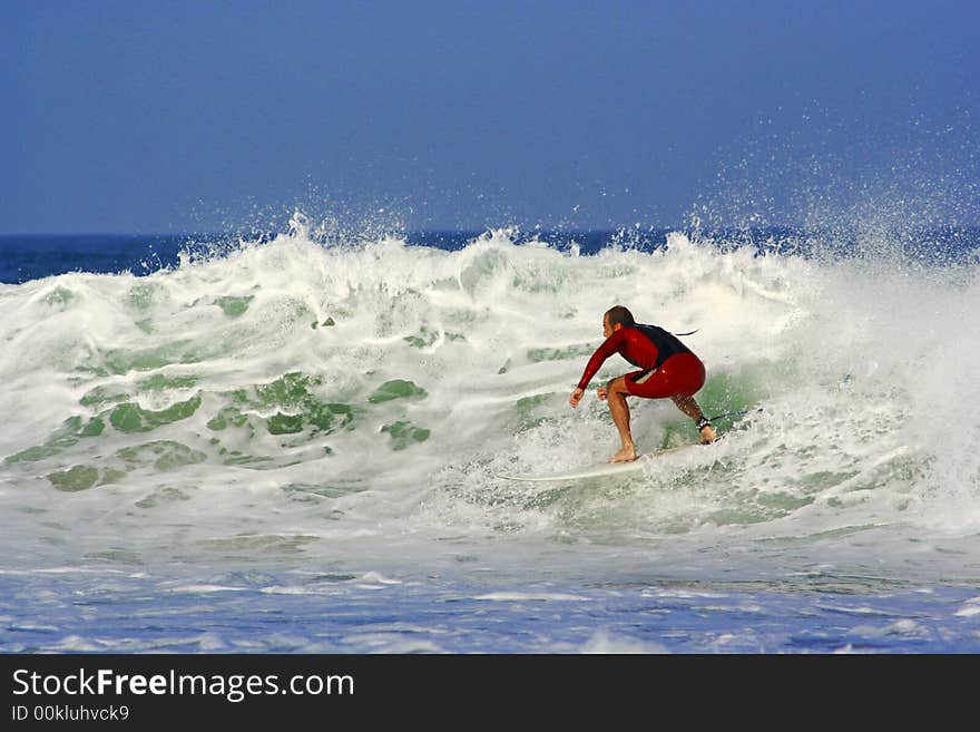 An image of a surfer doing a maneuver in the wave.