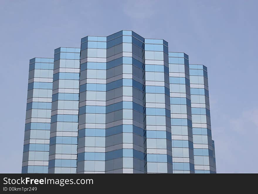 Many angled blue office building against blue sky. Many angled blue office building against blue sky