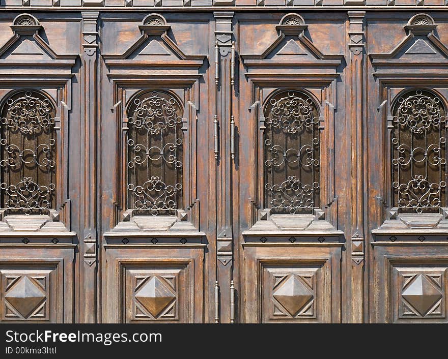 Old wooden doors with carvings and ornamented metal bars