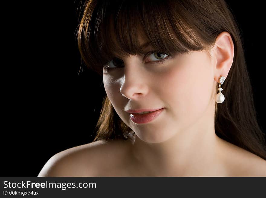 Brunette with earring on black background. Brunette with earring on black background