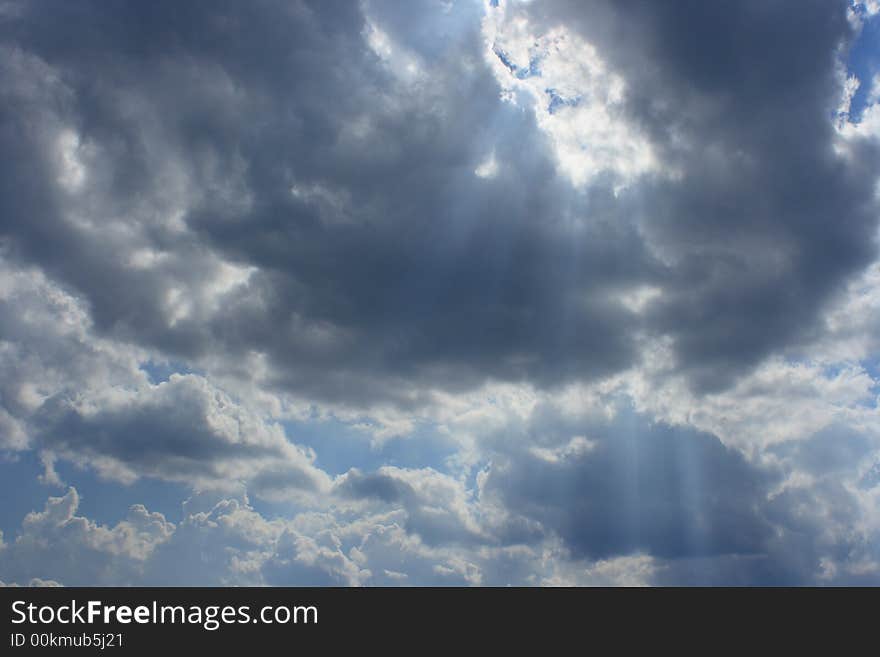 A break in the clouds accentuates the sun's rays shining down. A break in the clouds accentuates the sun's rays shining down.