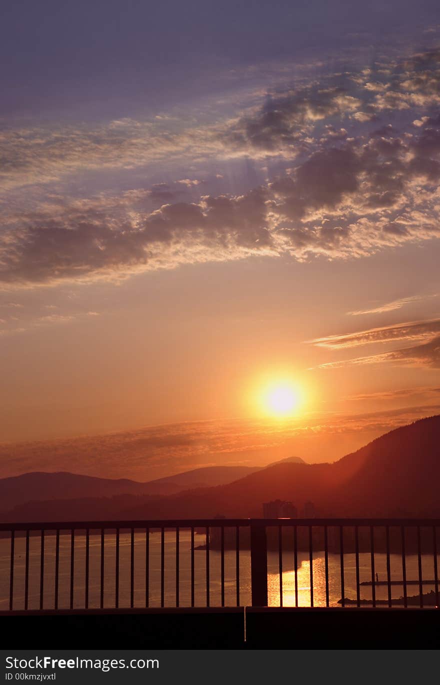 Beautiful sun setting behind mountains and big sky. Beautiful sun setting behind mountains and big sky