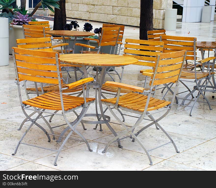 Outdoor, wooden modern patio furniture/table and chairs at a restaurant. Outdoor, wooden modern patio furniture/table and chairs at a restaurant