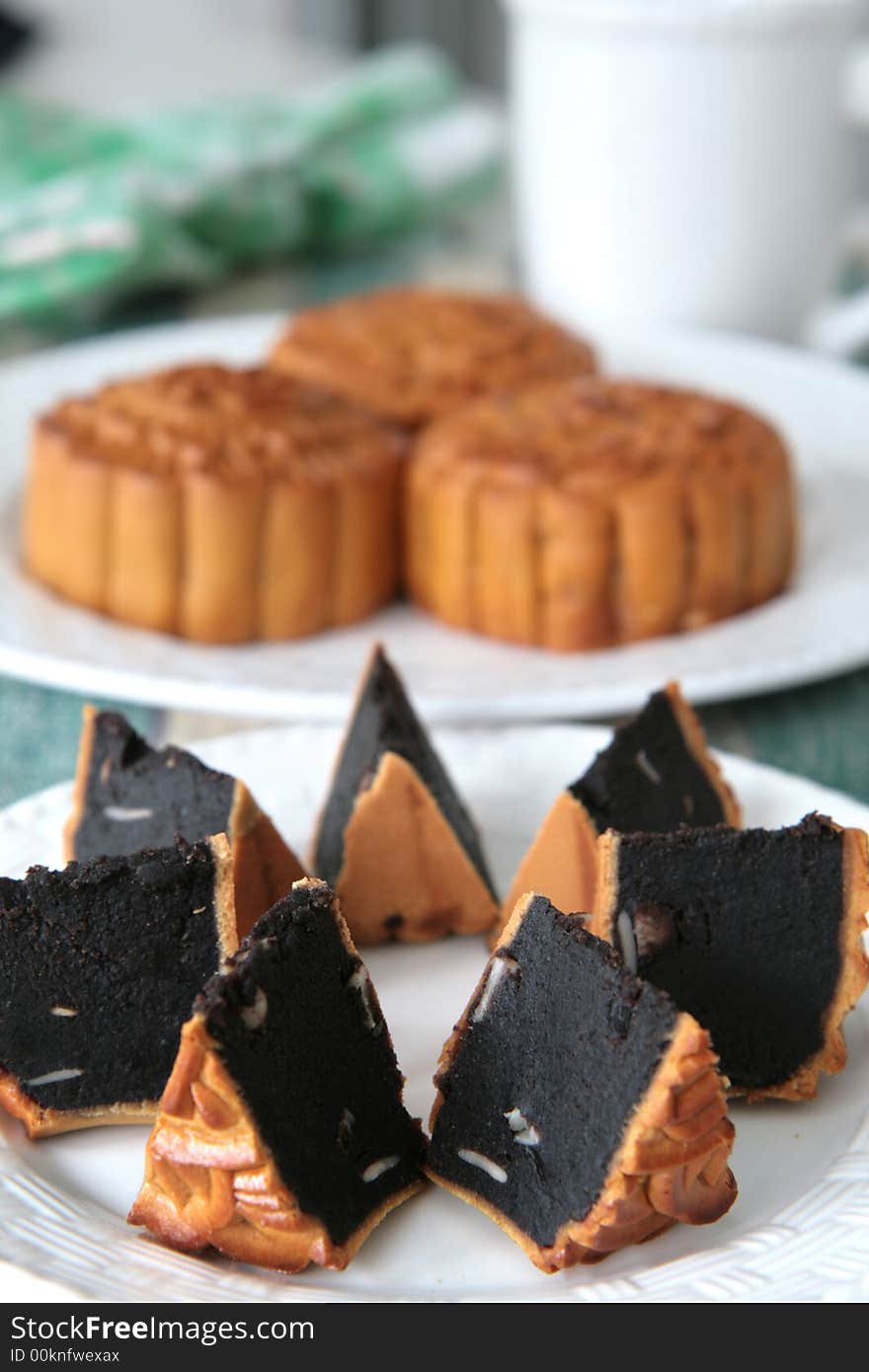 Wedge shaped portions of Chinese mooncake with red bean paste and melon seed filling. Wedge shaped portions of Chinese mooncake with red bean paste and melon seed filling