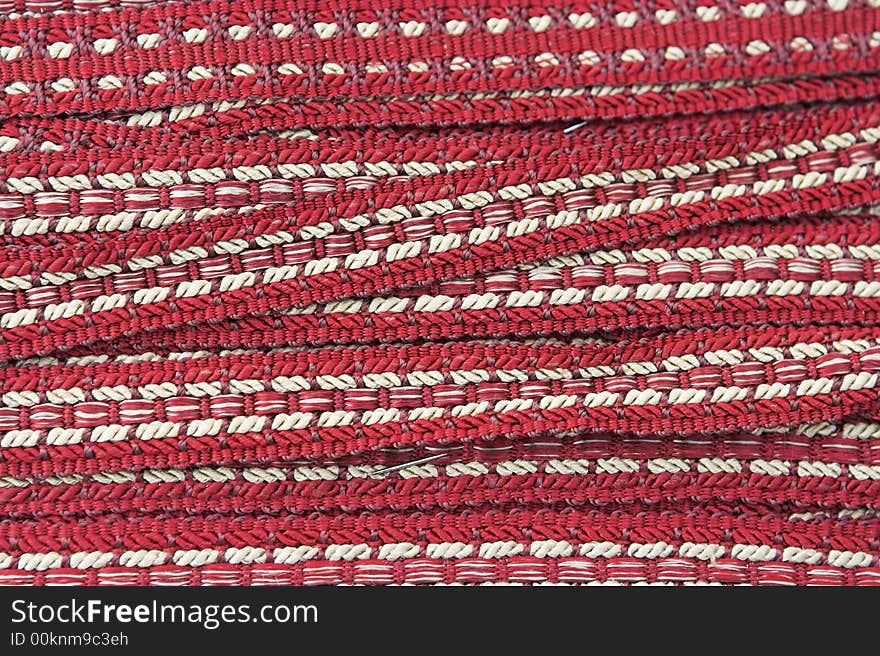 A card wrapped with antique red and white woven braid, for sale at a market. A card wrapped with antique red and white woven braid, for sale at a market.