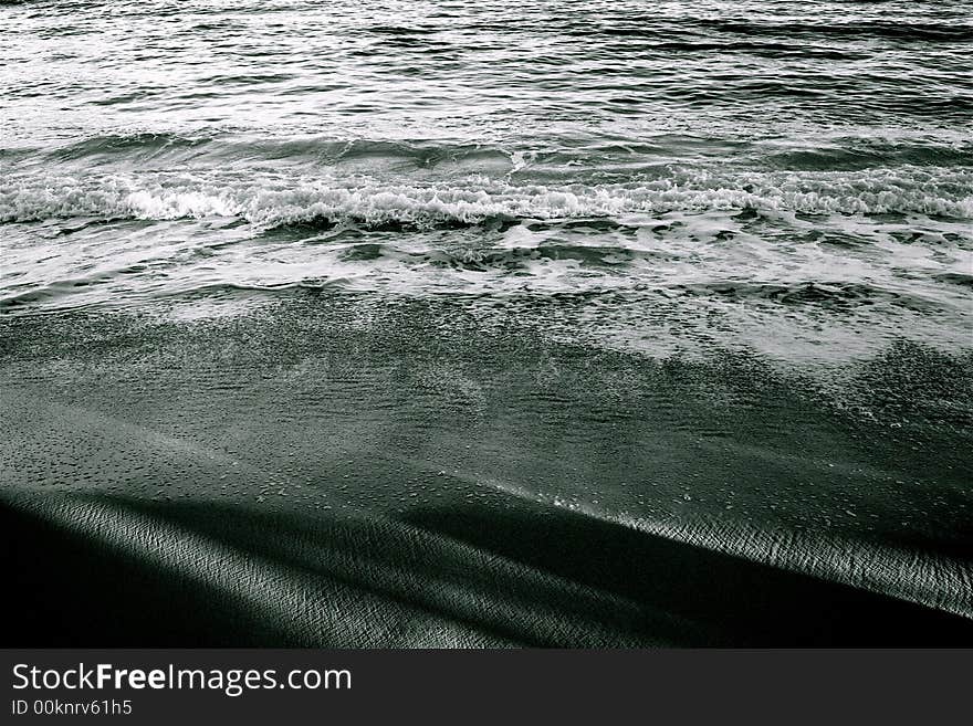 Snadows on the sand and waves breaking. Snadows on the sand and waves breaking