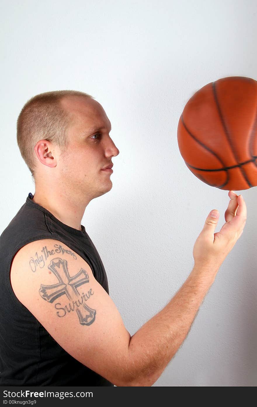 A young man with bright blue eyes and a basketball spinining on his finger! Isolated over white!. A young man with bright blue eyes and a basketball spinining on his finger! Isolated over white!