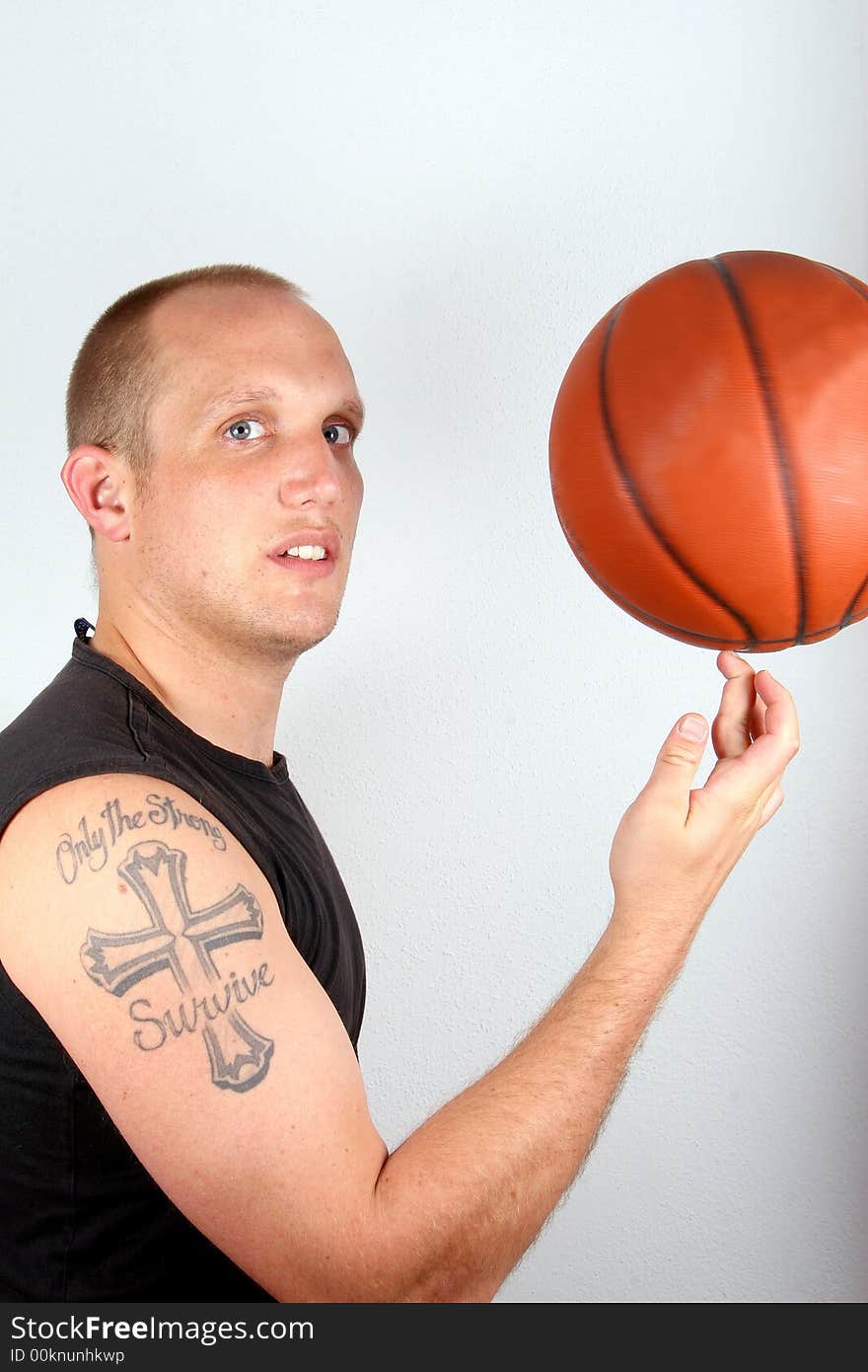 A young man with bright blue eyes and a basketball spinining on his finger! Isolated over white!. A young man with bright blue eyes and a basketball spinining on his finger! Isolated over white!