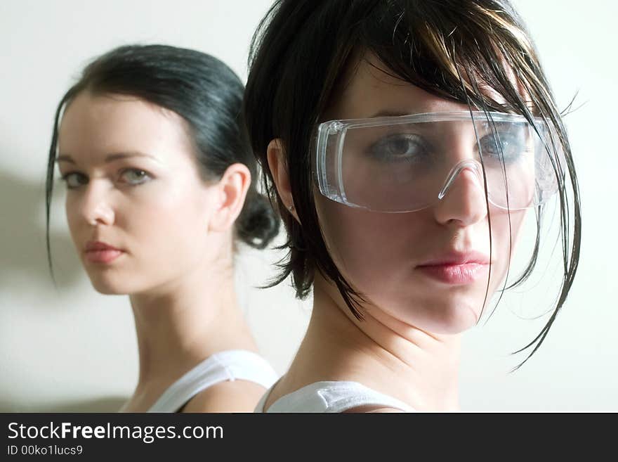 Two attractive girls looking into the camera. Focal point is on the right face. Two attractive girls looking into the camera. Focal point is on the right face.