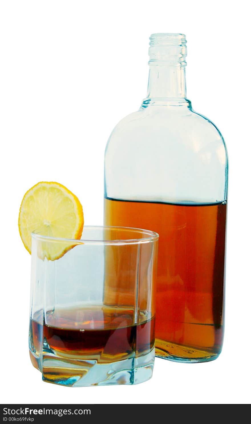 Bottle of cognac, glass with cognac and a lemon