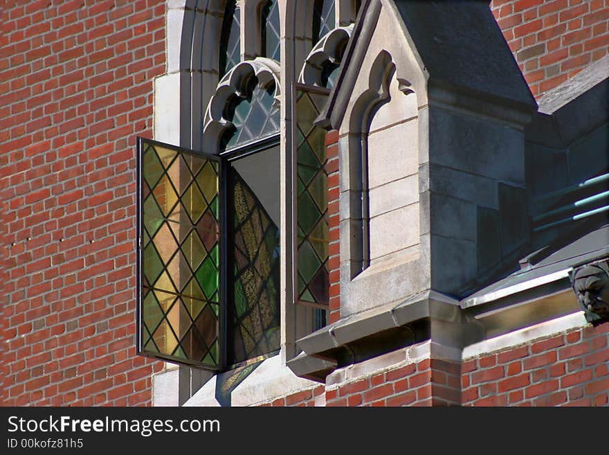 Beautiful opened stained glass window on a old chapel. Intricate architecture on chapel. Beautiful opened stained glass window on a old chapel. Intricate architecture on chapel.