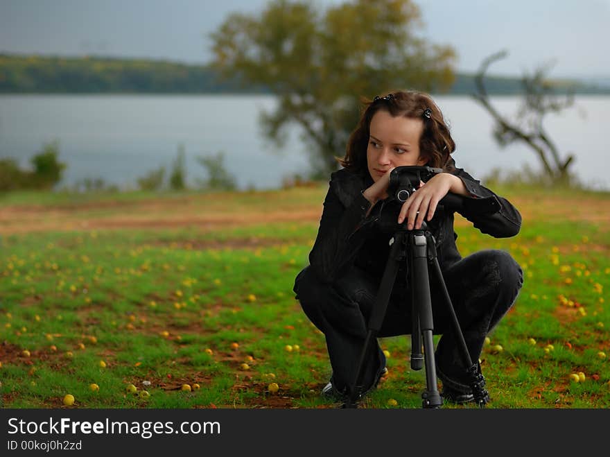 The girl - the photographer. The girl considers construction of a picture, early autumn