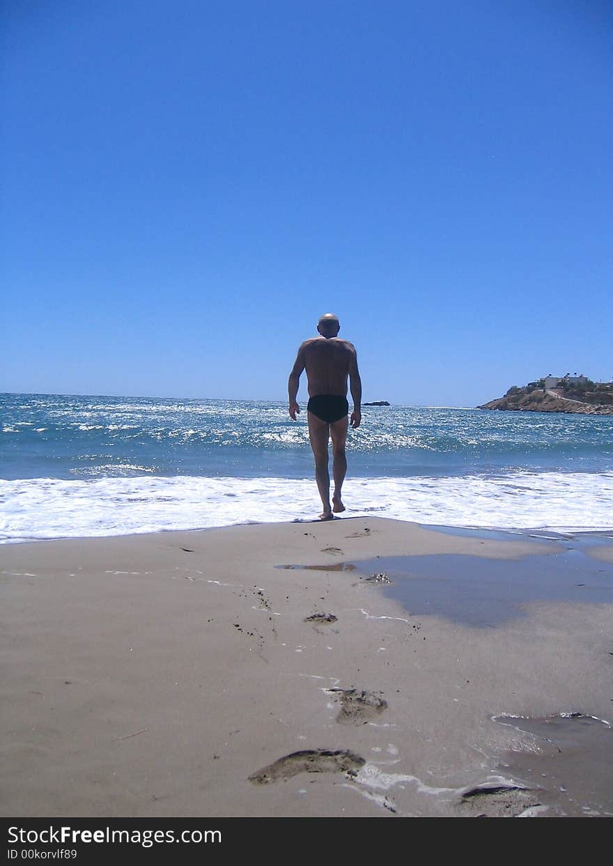 Man going into the ocean to swim. Man going into the ocean to swim