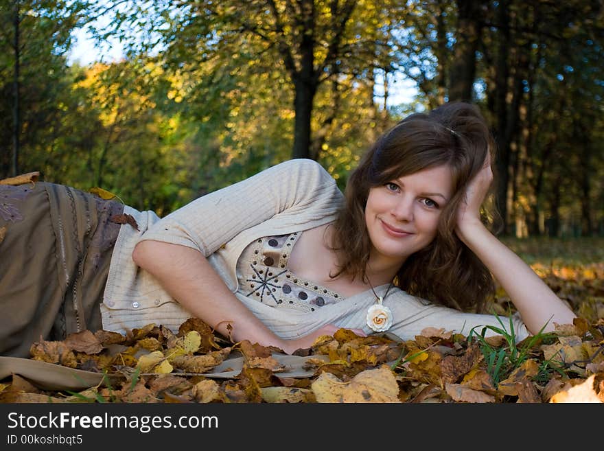 Girl lying on autumn leaves in park. Girl lying on autumn leaves in park