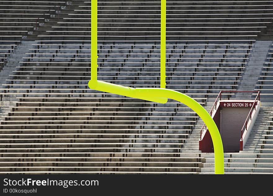 Green goal posts in front of deserted stadium seats. Green goal posts in front of deserted stadium seats.