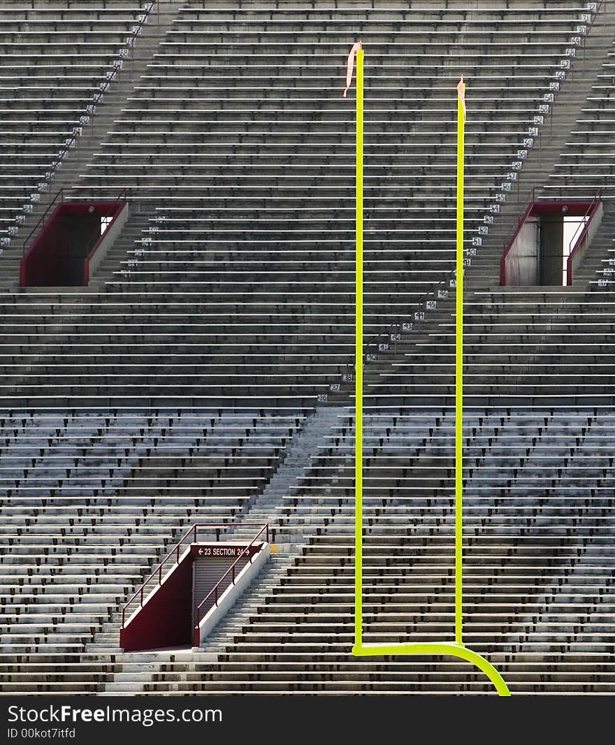 Green goal posts in front of deserted stadium seats. Green goal posts in front of deserted stadium seats.