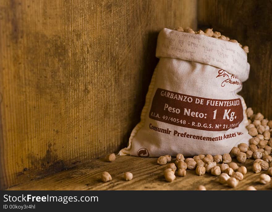 A small sack of Spanish grown garbanzo beans (chickpeas) in a rustic looking old wooden crate. A small sack of Spanish grown garbanzo beans (chickpeas) in a rustic looking old wooden crate.