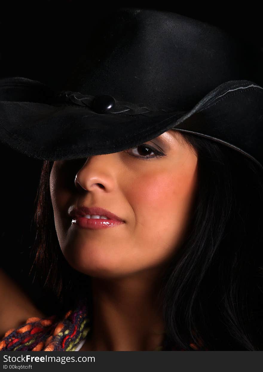 Beautiful latino with a hat posing over black. Beautiful latino with a hat posing over black