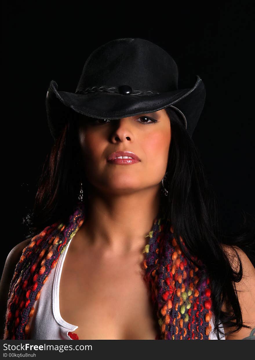 Beautiful latino with a hat posing over black. Beautiful latino with a hat posing over black