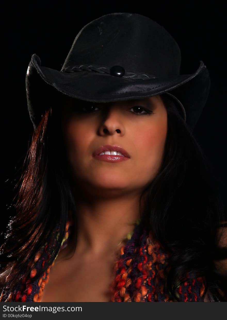 Beautiful latino with a hat posing over black. Beautiful latino with a hat posing over black