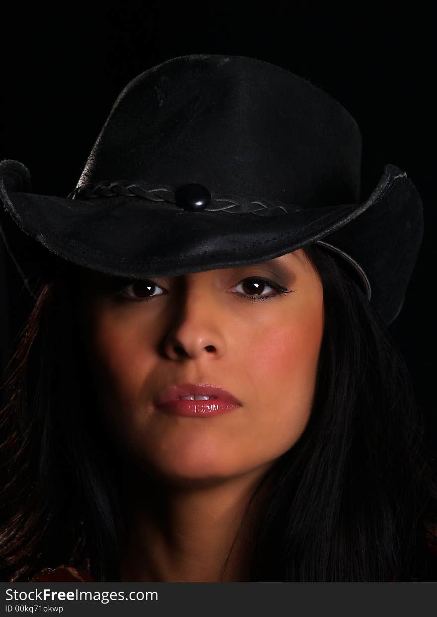 Beautiful latino with a hat posing over black. Beautiful latino with a hat posing over black