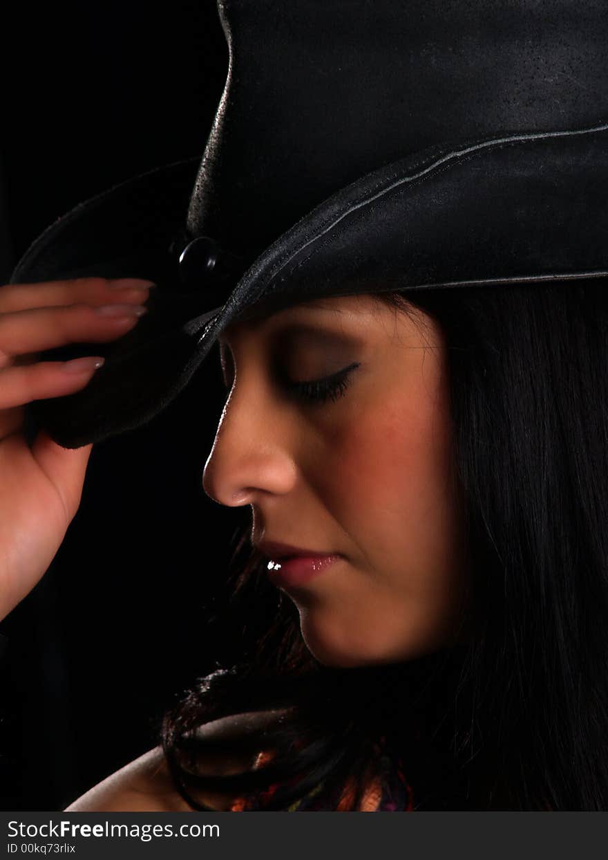 Beautiful latino with a hat posing over black. Beautiful latino with a hat posing over black