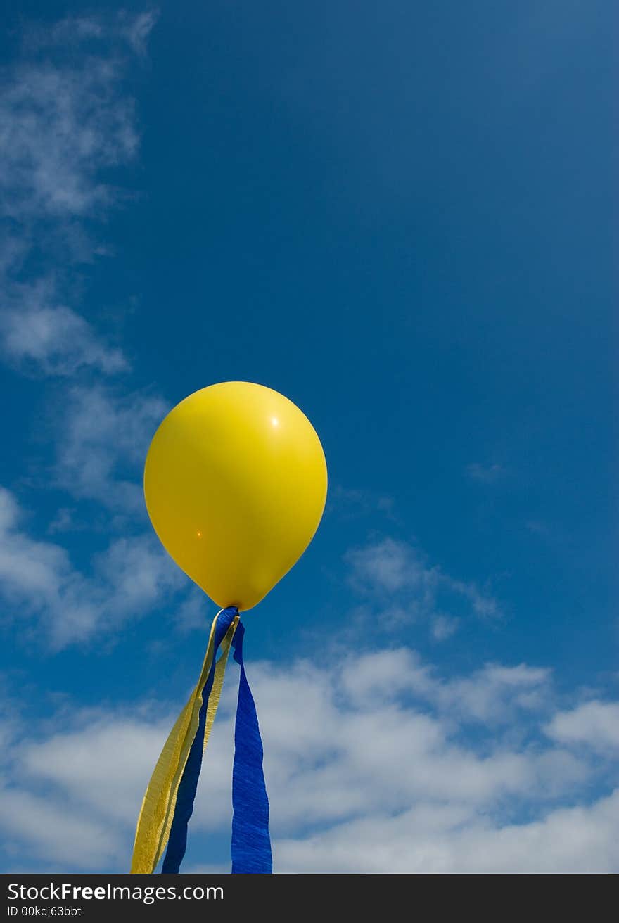 A yellow balloon on a blue sky