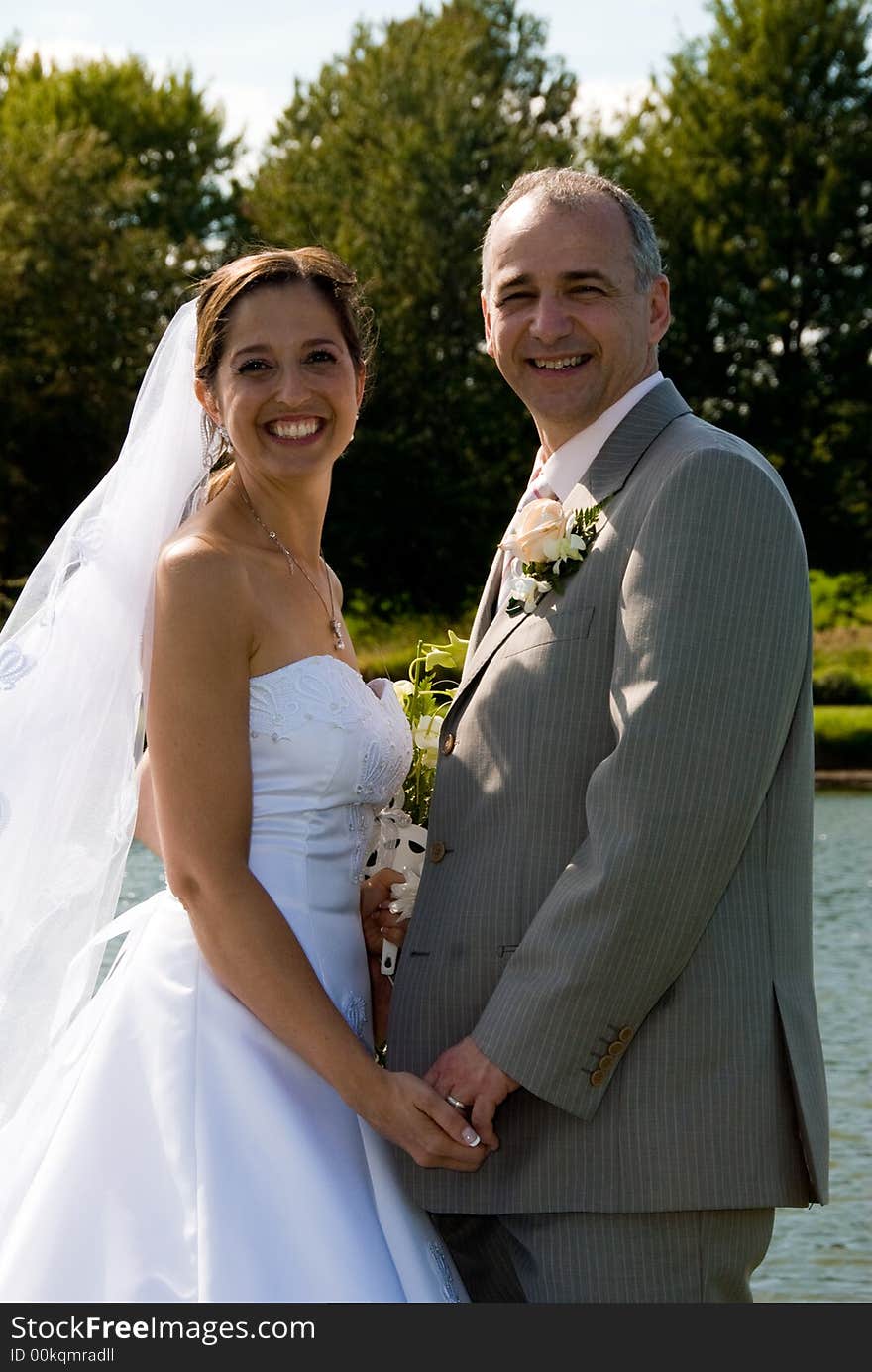 A just married man and woman by a lake. A just married man and woman by a lake