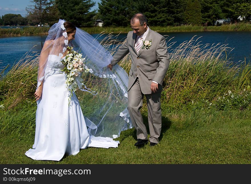 A just married man and woman by a lake. A just married man and woman by a lake