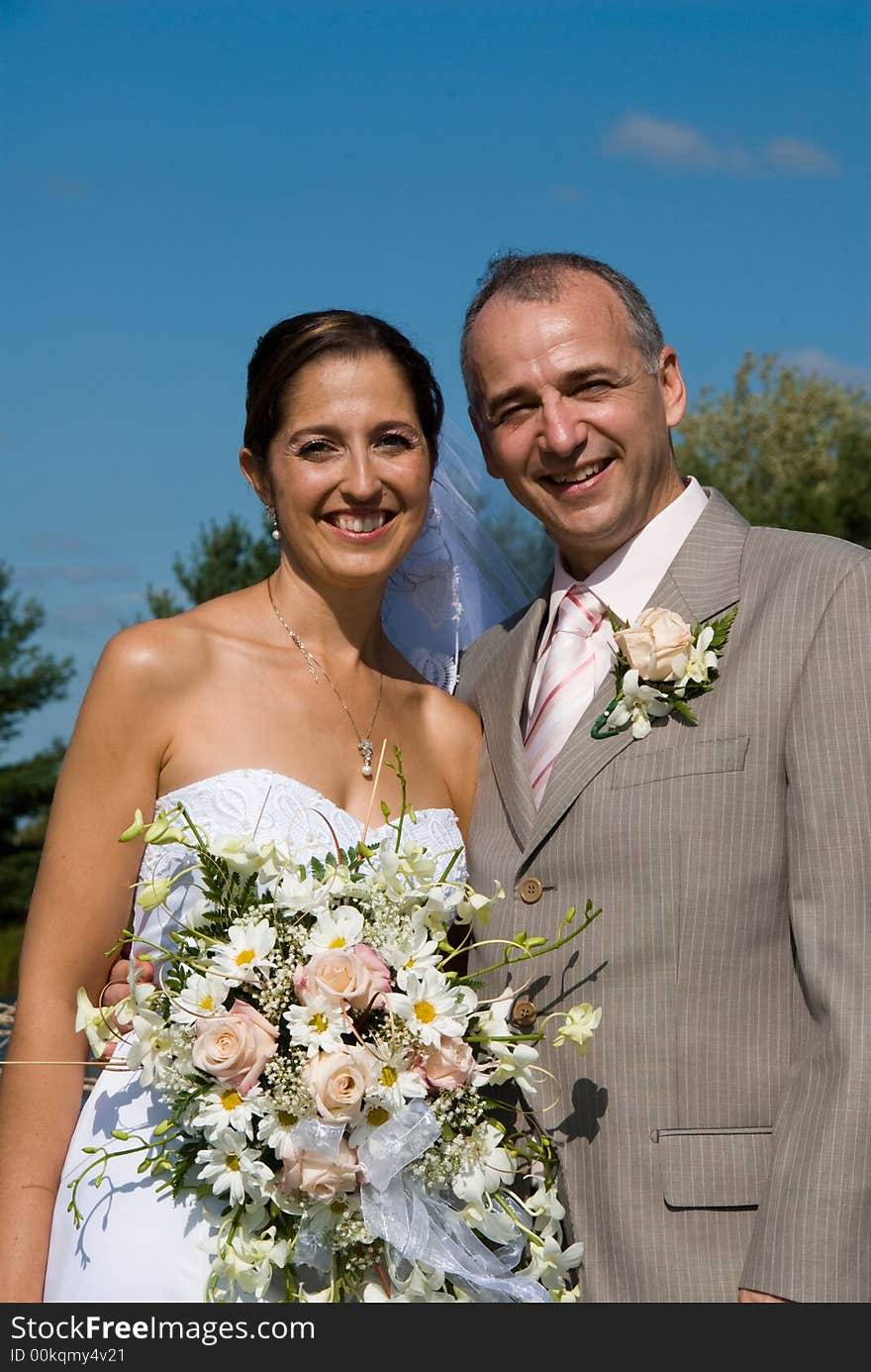 A just married man and woman by a lake. A just married man and woman by a lake