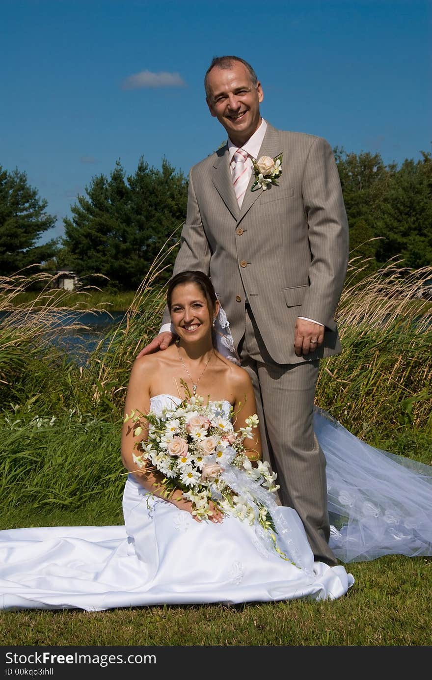 A just married man and woman by a lake. A just married man and woman by a lake