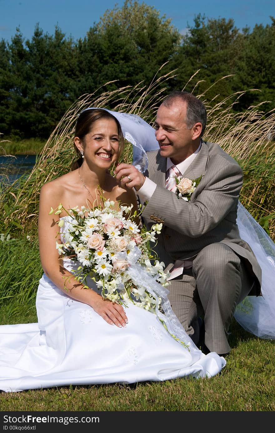 A just married man and woman by a lake. A just married man and woman by a lake