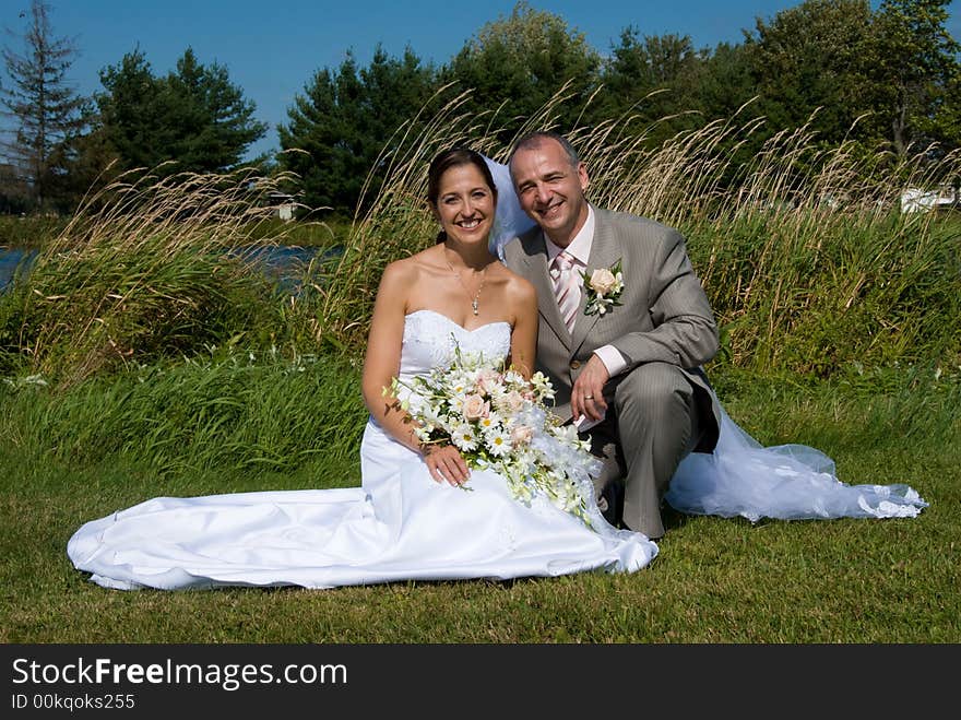 A just married man and woman by a lake. A just married man and woman by a lake