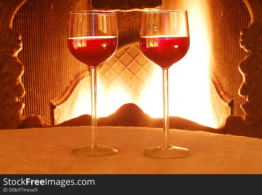 Two glass of wine against the fire background.