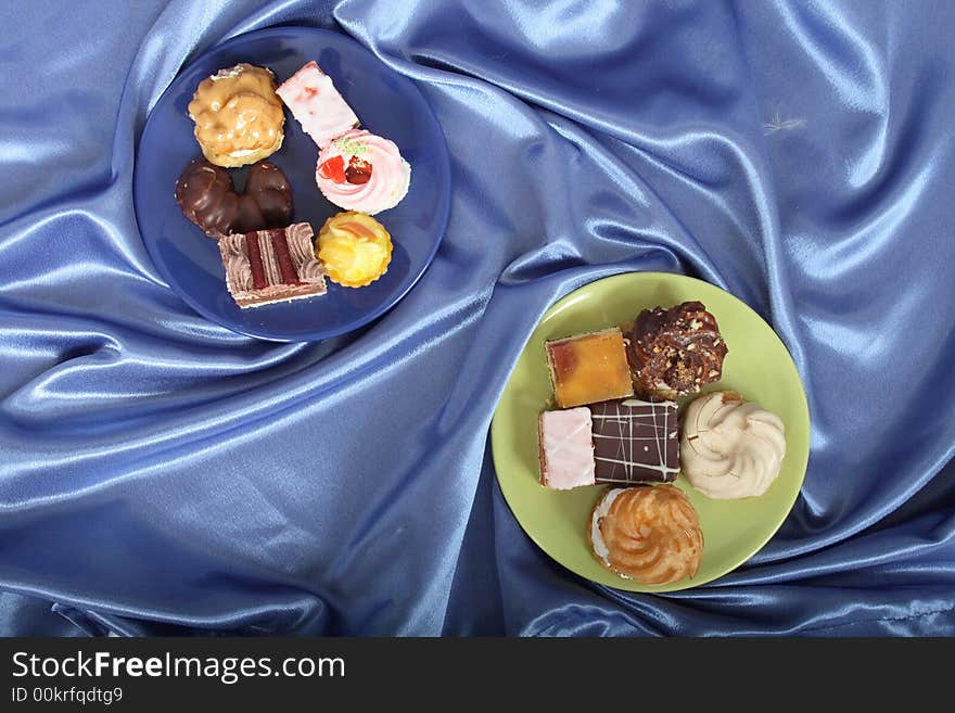 Sweet deserts on color plates on the blue background