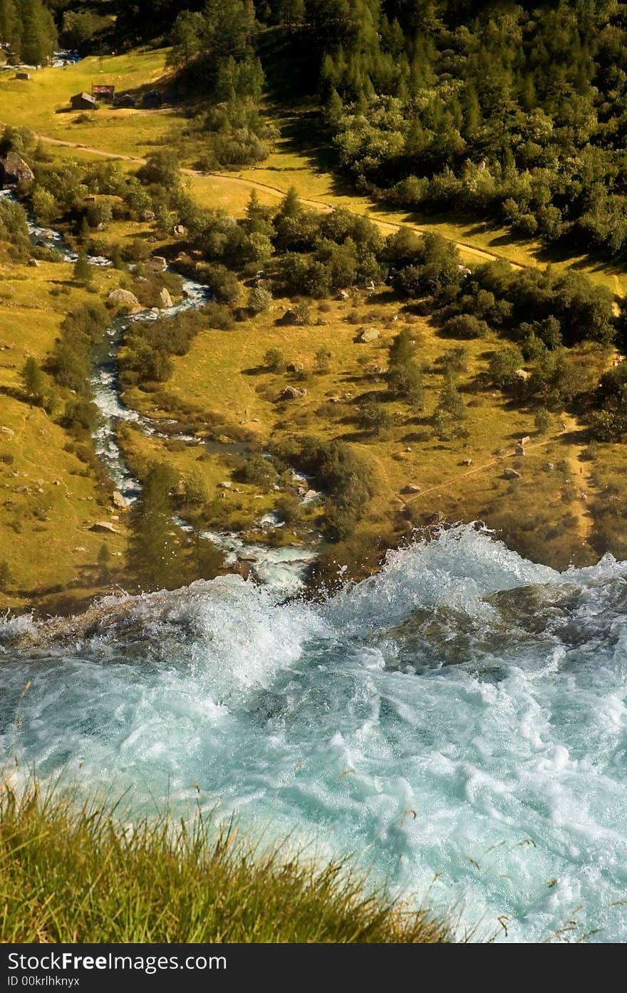 Waterfall overlooking alpine landscape and valley