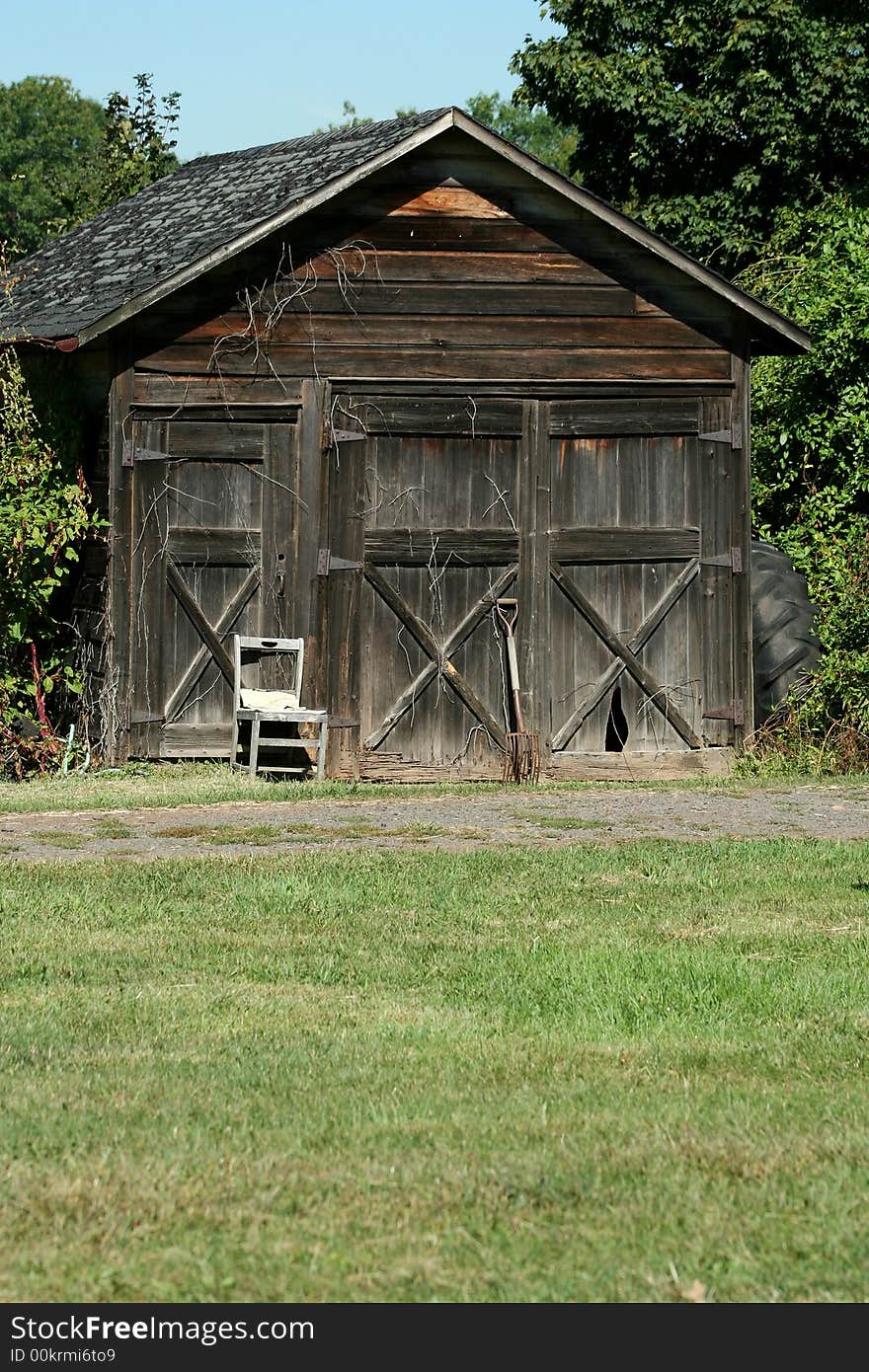 An Old wooden barn with grass and sky. An Old wooden barn with grass and sky