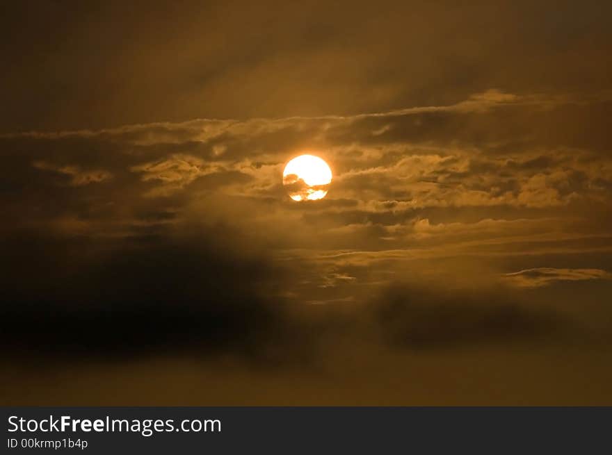 Sunset at the boat ramp off Mattapoisett Neck Road in Mattapoisett, MA, USA. The sun is visible on an orange/black background and foreground with clouds and room for text. Sunset at the boat ramp off Mattapoisett Neck Road in Mattapoisett, MA, USA. The sun is visible on an orange/black background and foreground with clouds and room for text.