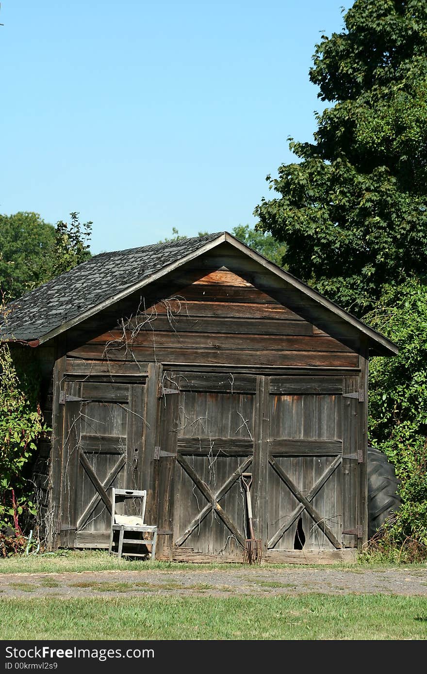 An Old wooden barn with grass and sky. An Old wooden barn with grass and sky