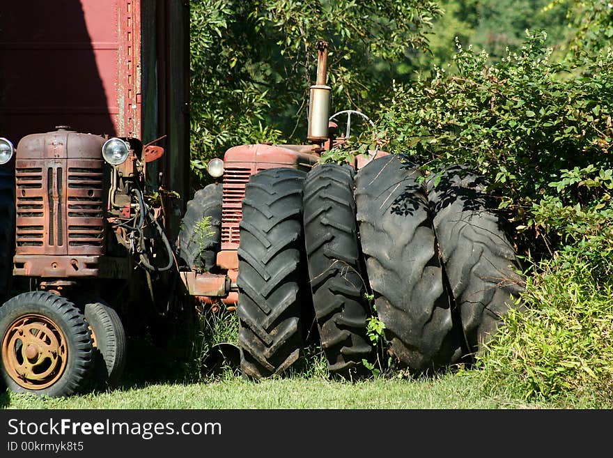 Two Old red tractors with tires