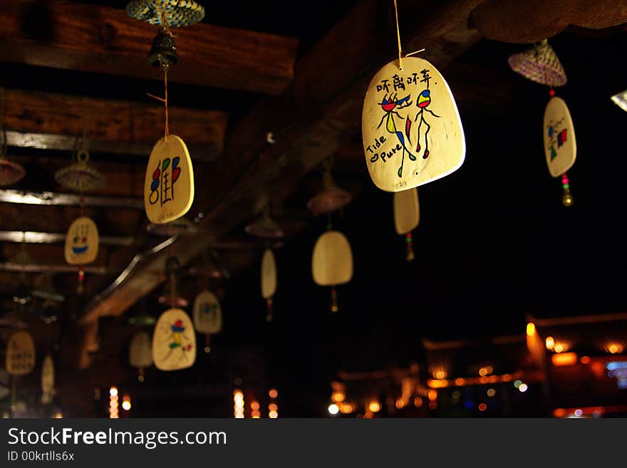 Wooden hanging cards in Lijiang with hieroglyphic characters, symbol for wishes. Characters on the one in focus mean 'neither leave nor abandon'