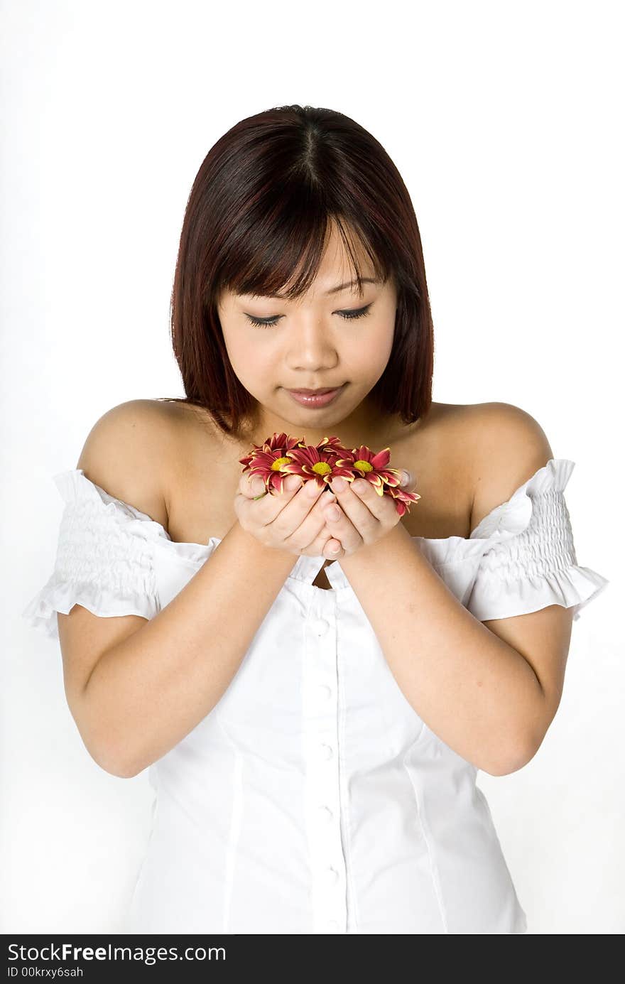 A beautiful asian women smelling flowers in a stuido. A beautiful asian women smelling flowers in a stuido