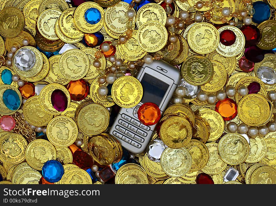 Vivid picture of a cell phone in a pile of jewels - ideal for illustrating the essential role of communication in financial prosperity. Vivid picture of a cell phone in a pile of jewels - ideal for illustrating the essential role of communication in financial prosperity.