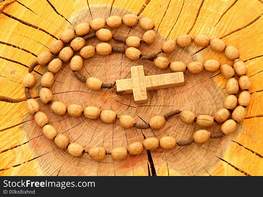 Wooden rosary on wooden background. Religion related item.