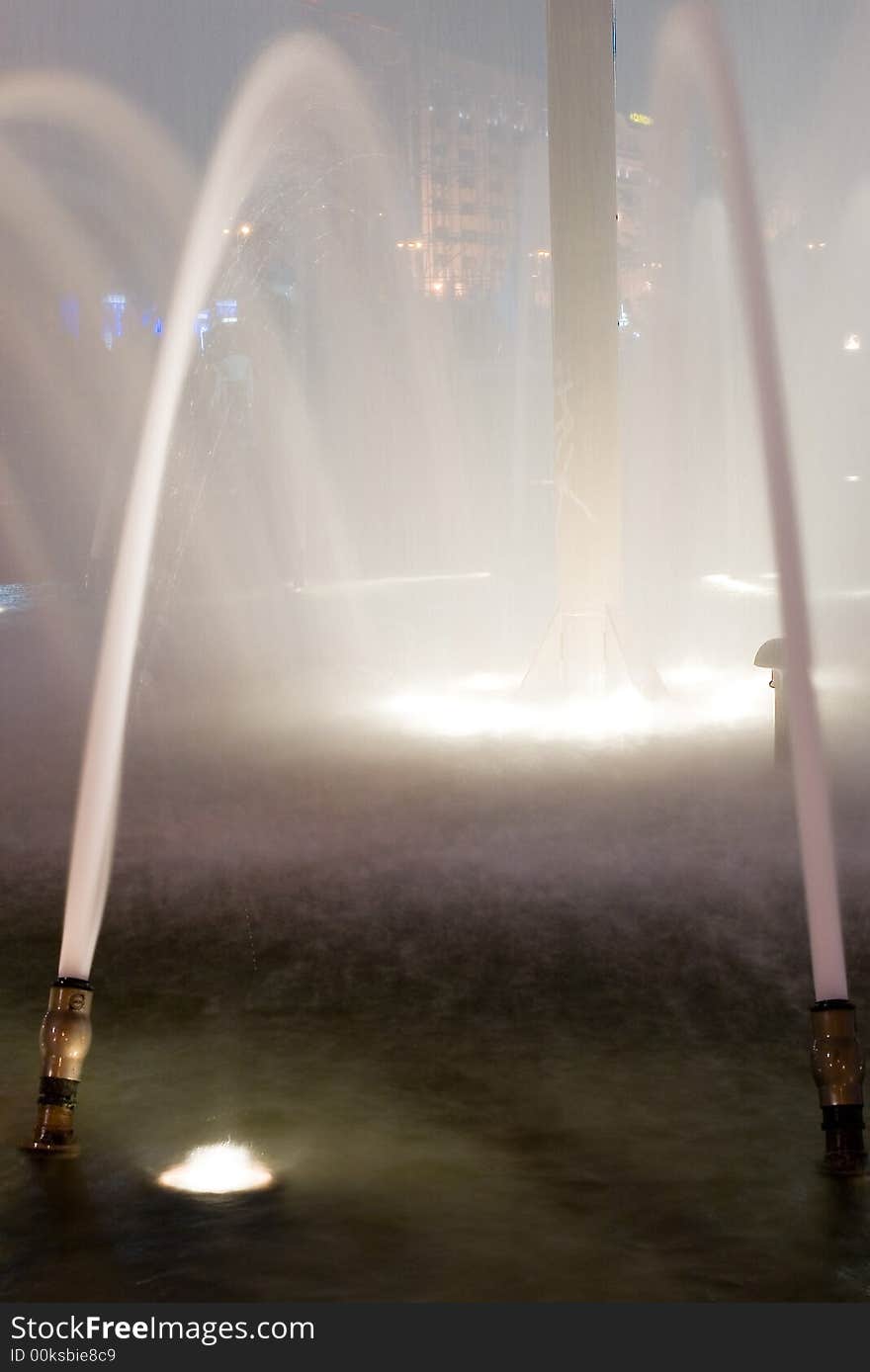 An impressive view of a water fountain at night at its full height. An impressive view of a water fountain at night at its full height